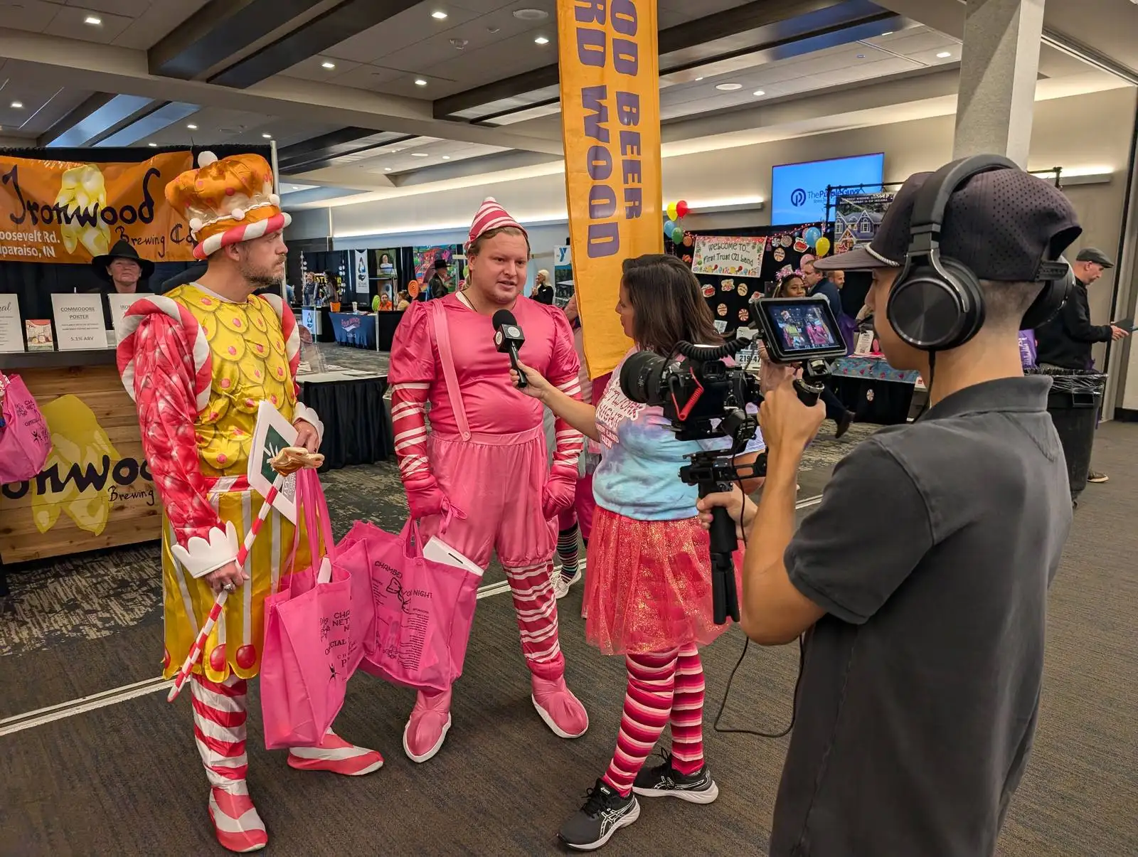A DuneVision camera on a tripod at a crowded indoor community event